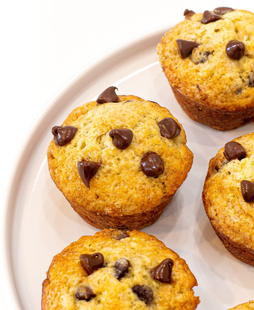 Banana chocolate chip muffins served on a white plate.