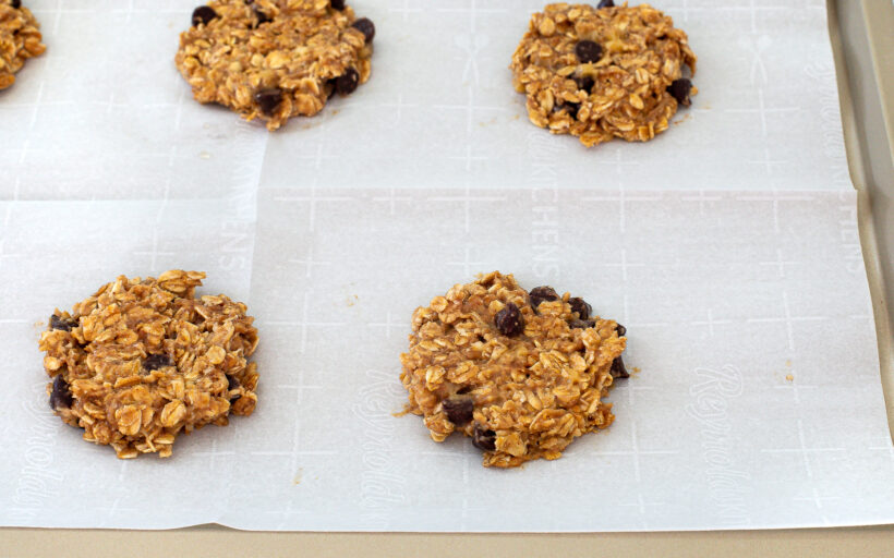 Healthy banana oatmeal cookies on a baking sheet lined with parchment paper before being baked. 