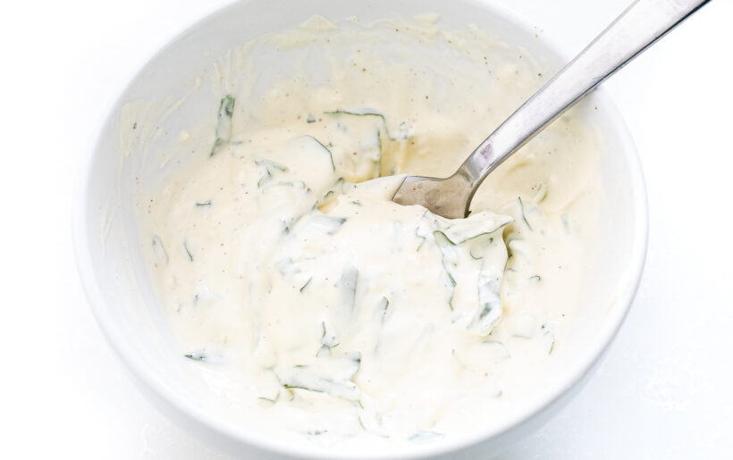 Basil garlic mayo in a small bowl with a spoon.