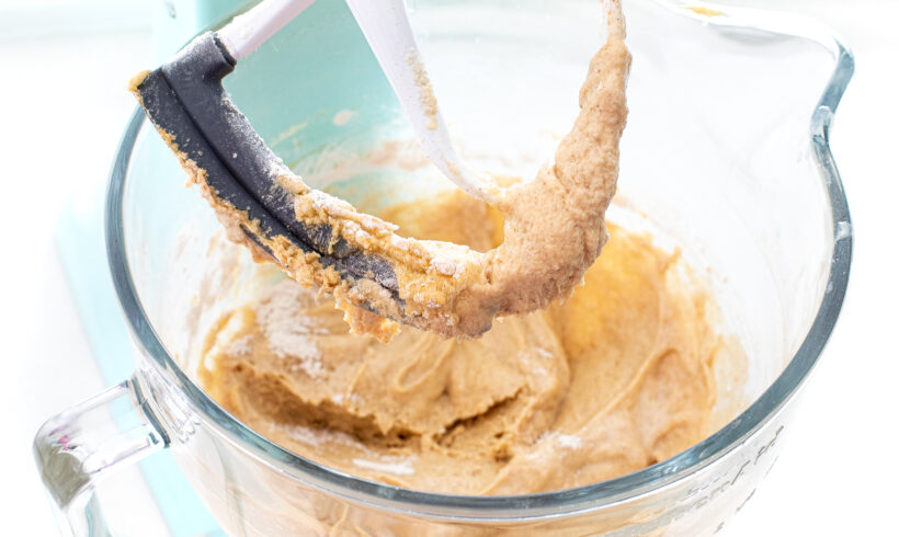 Cake batter in the bowl of a stand mixer with the paddle attachment.