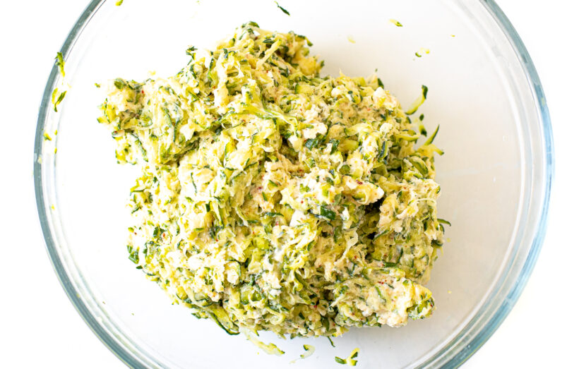 Zucchini fritters mixture in a mixing bowl.