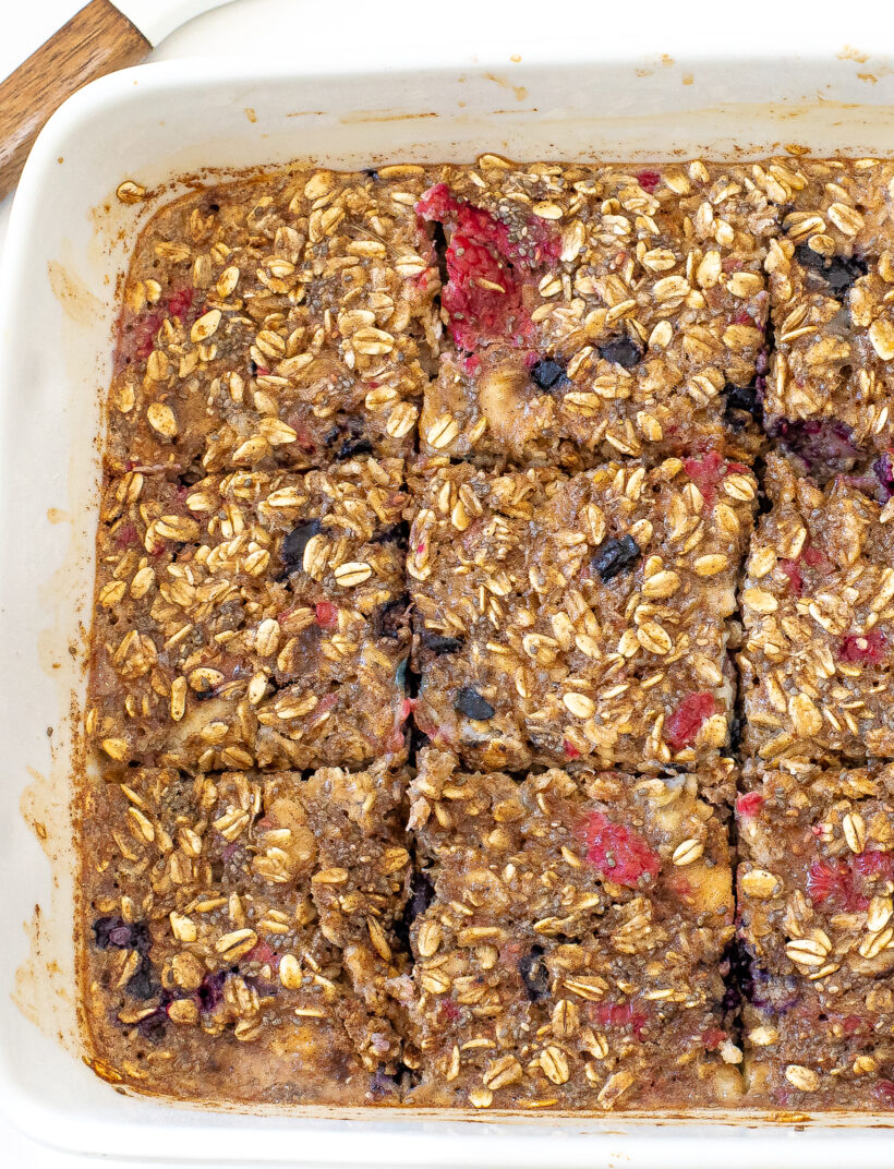 Berry baked oatmeal in a baking dish cut into slices.