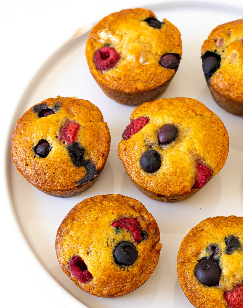 Berry muffins lined up on a serving plate.