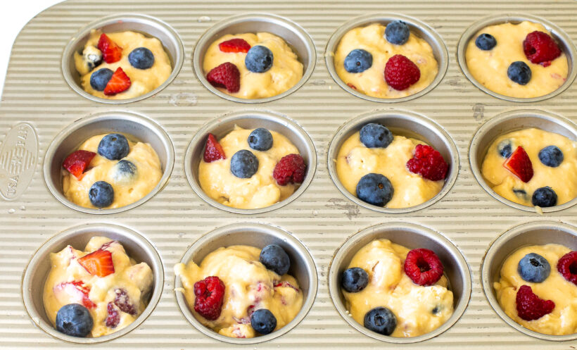 Muffin batter in a muffin tin before being baked.