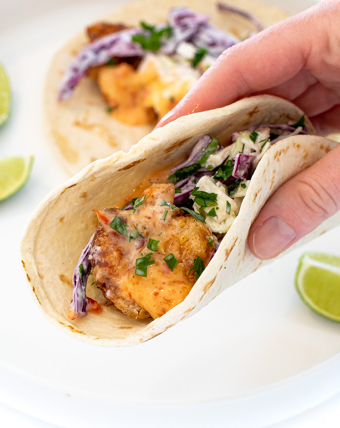 Hand holding a bang bang shrimp taco. 