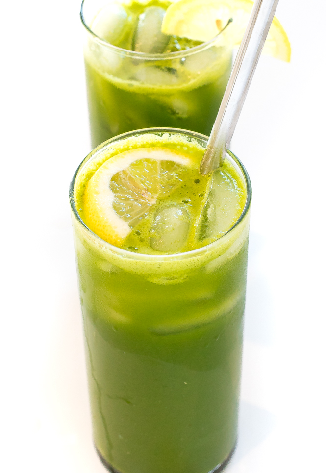Green juices topped with slices of lemon in tall glasses.
