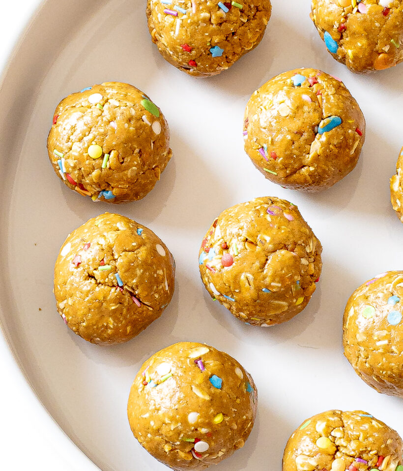 Birthday cake energy balls on a white plate. 