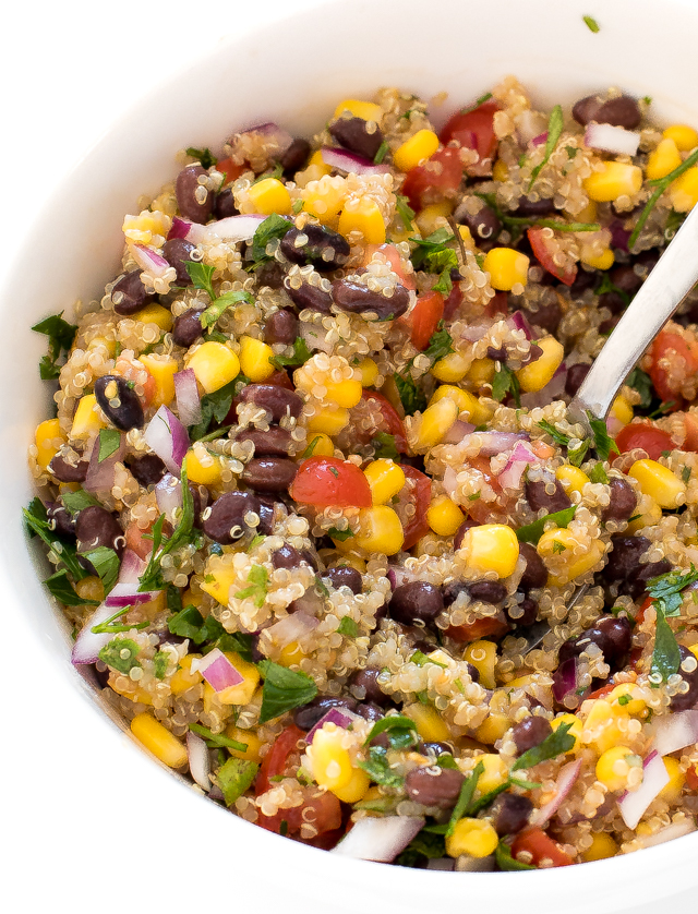 Tomato and Black Bean Quinoa Salad in large white bowl with spoon
