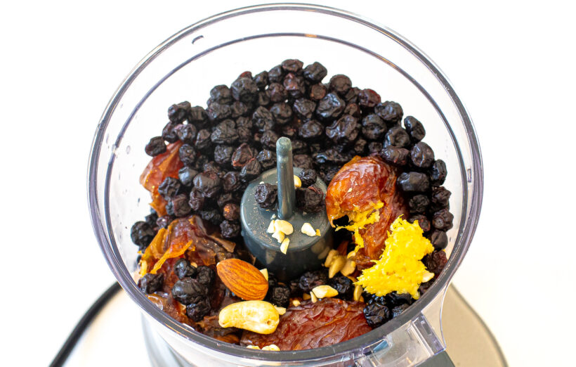Ingredients needed for blueberry energy bites in a food processor before being blended. 