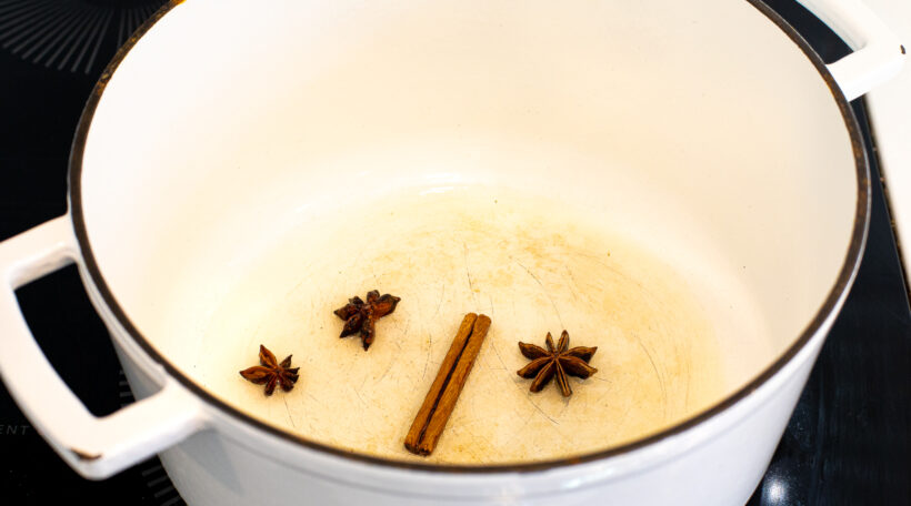 blooming spices in white cast iron pot