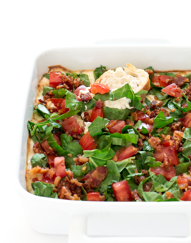 BLT Dip | chefsavvy.com Dip in a white baking dish with a piece of bread with dip on it.