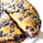 Blueberry cake with a cake spatula holding a slice.