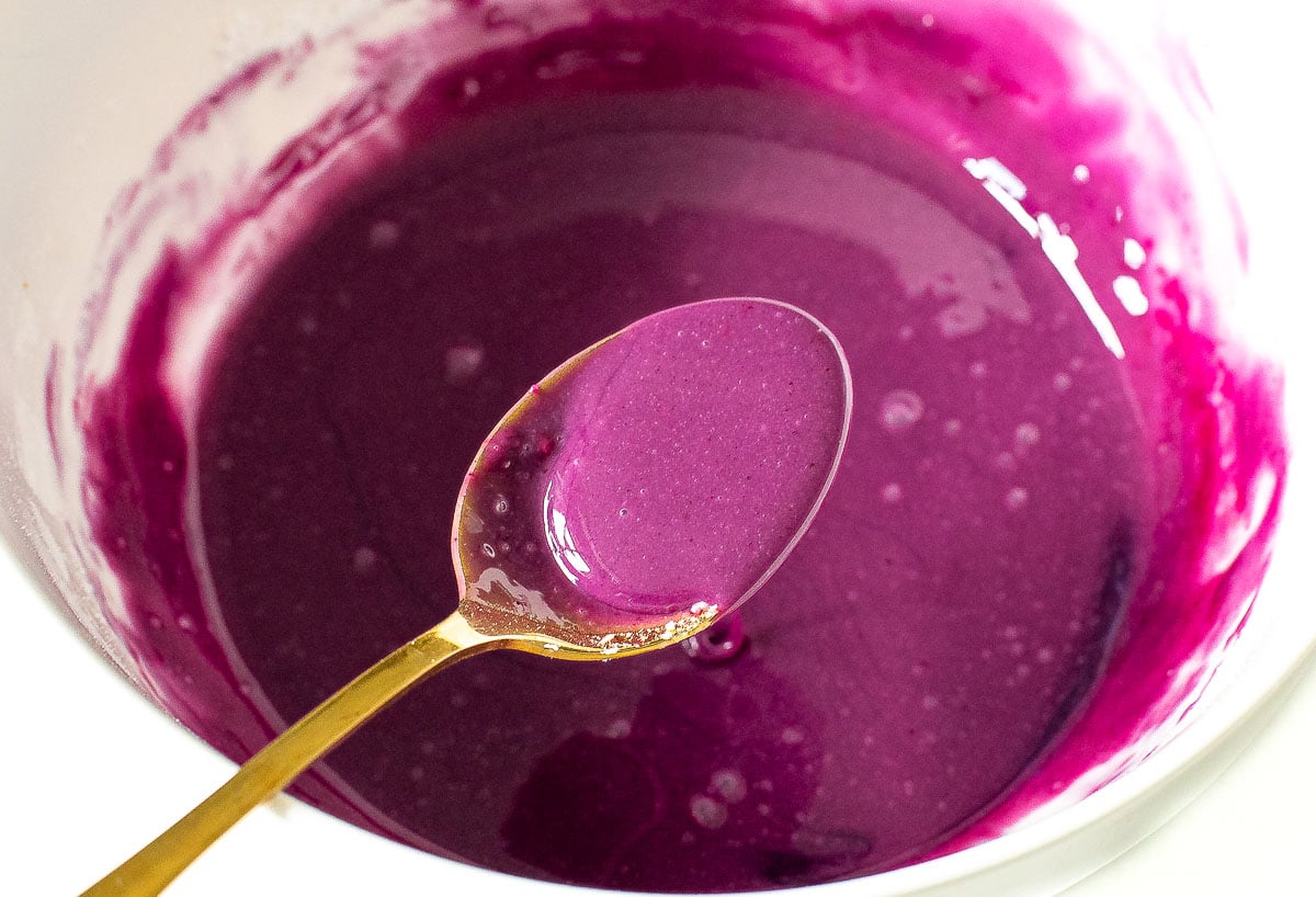 adding blueberry reduction to powdered sugar and milk