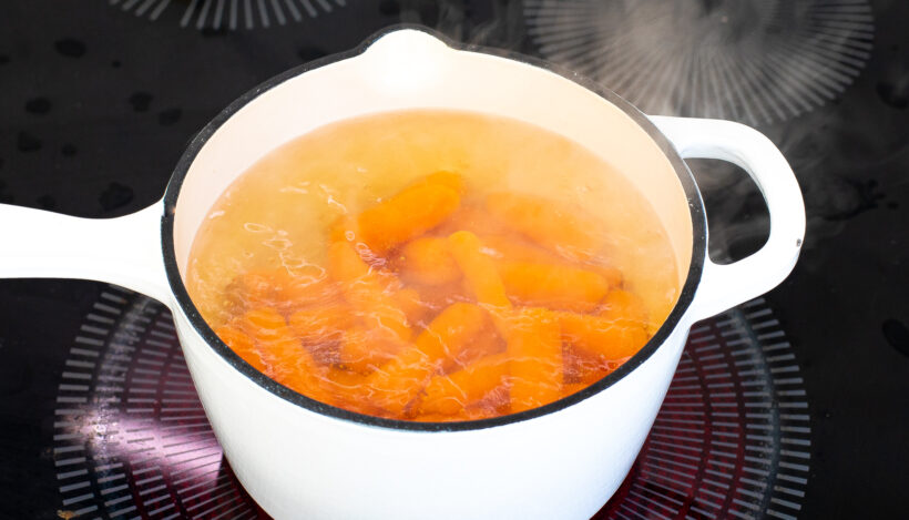 Carrots boiling in a saucepan.