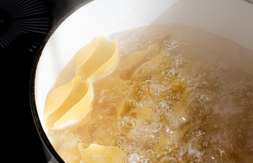 Jumbo shell pasta boiling in a pot. 