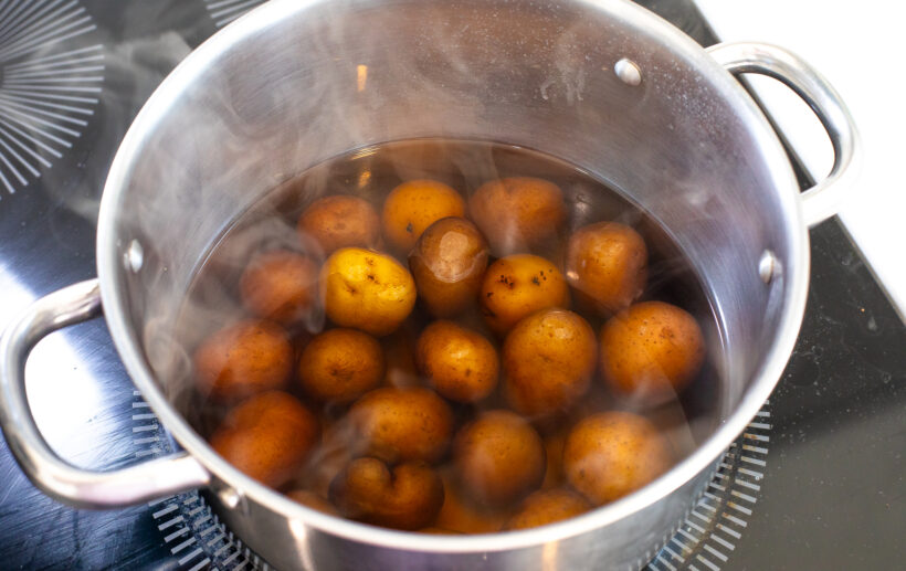 Potatoes cooking in a pot of water.