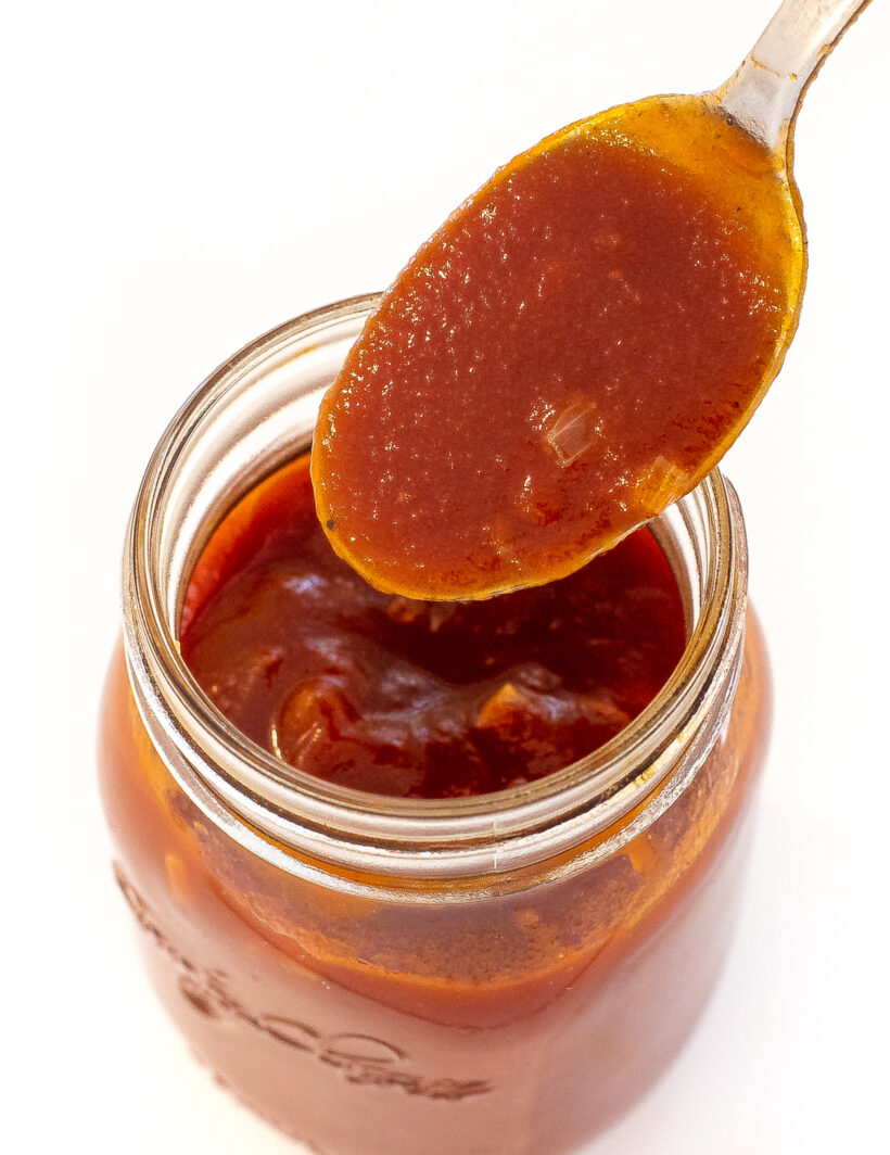 spooning out bourbon barbecue sauce out of mason jar