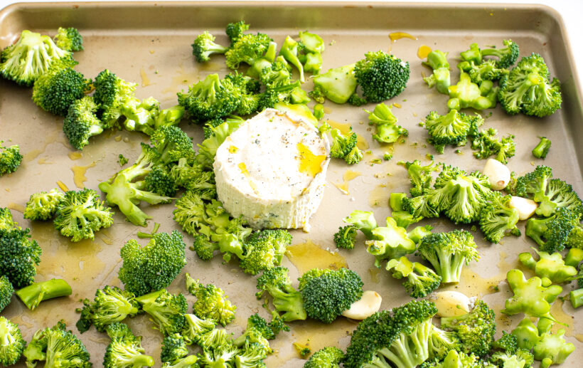 Broccoli and boursin cheese laid out on a sheet pan. 