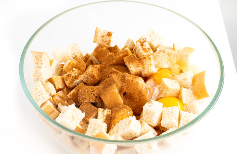 Eggnog casserole ingredients in a glass mixing bowl.