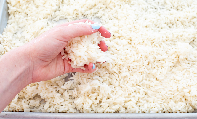 author baking up clumps of white rice on a baking sheet