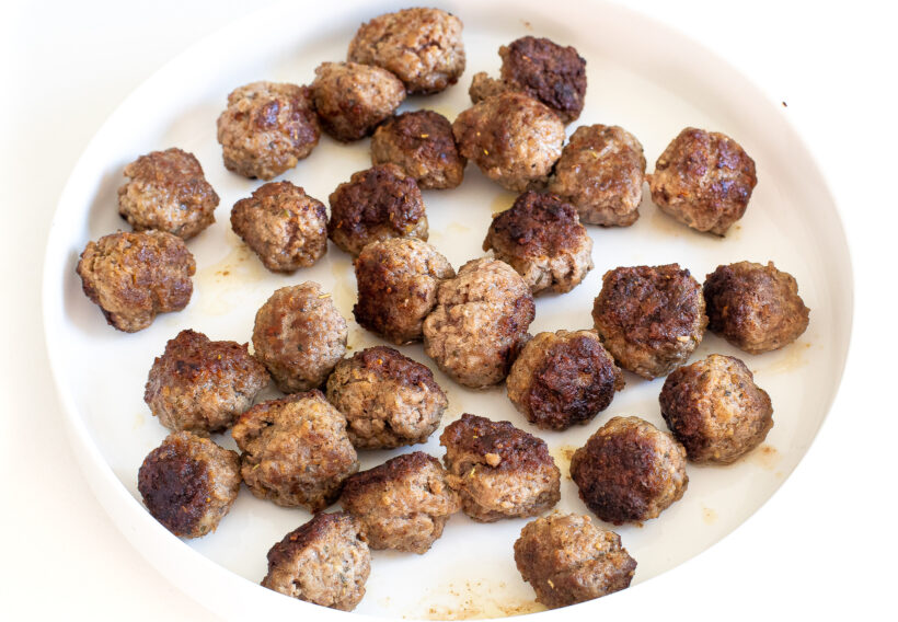 setting meatballs aside on large white plate
