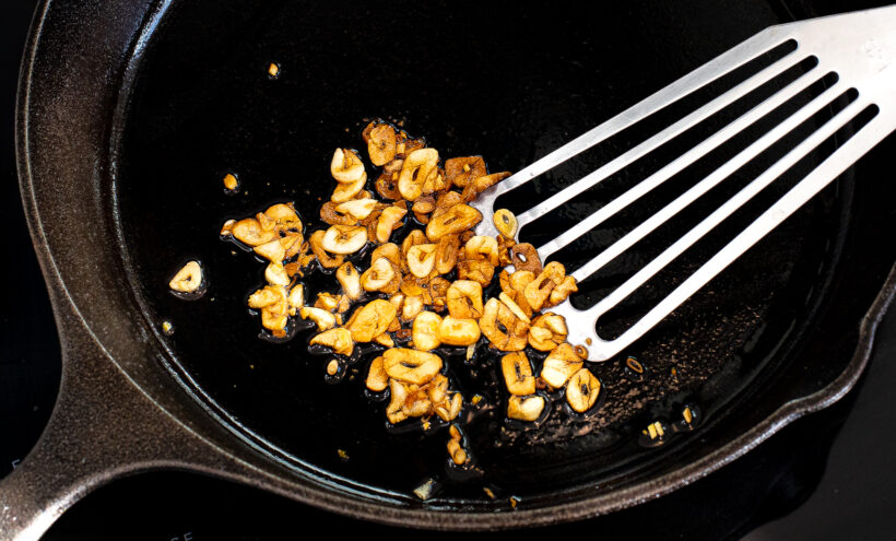 Cooked sliced garlic in a skillet.