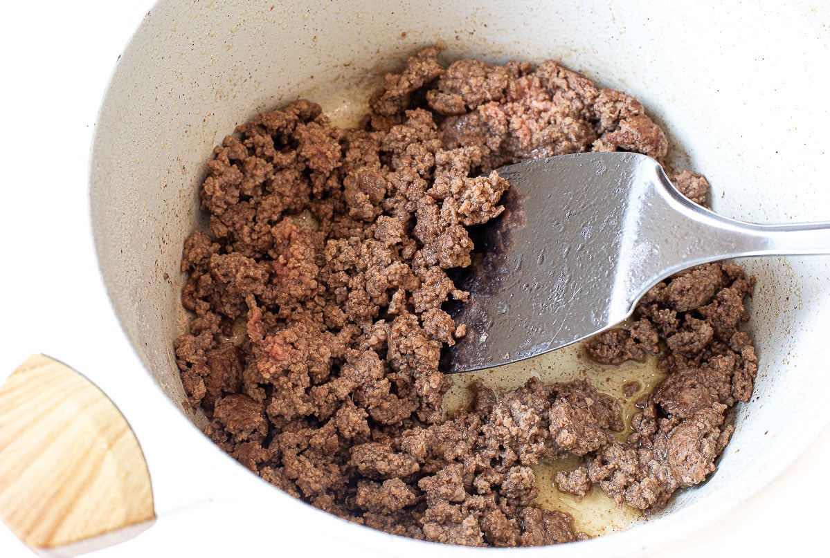 Browning ground beef with a spatula.