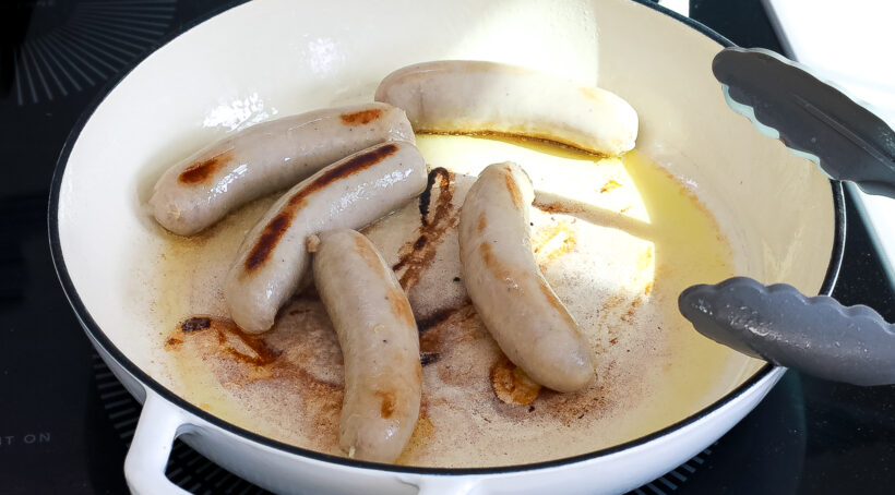 browning pork sausages in large skillet
