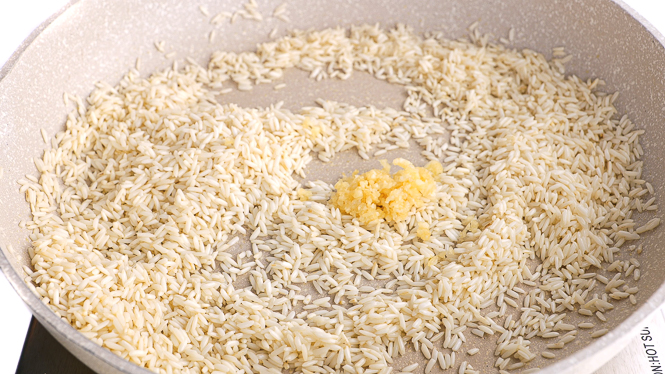toasting rice and minced garlic in large skillet
