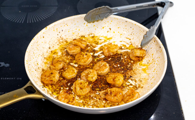 Shrimp searing in a skillet.