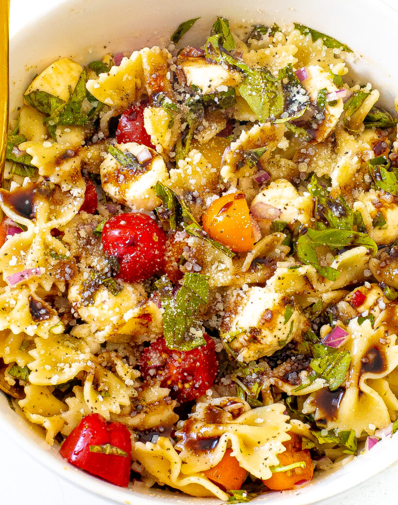 Close up shot of bruschetta pasta salad in a white bowl. 