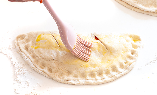 brushing calzones with egg wash