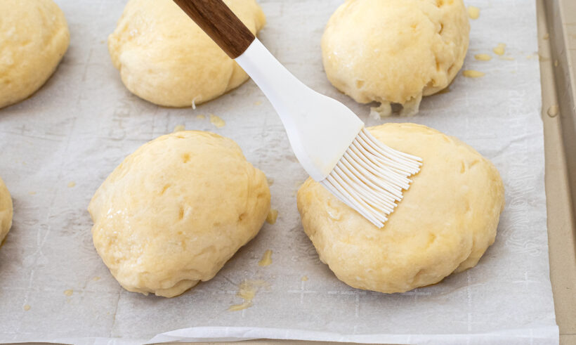 brushing buns with egg wash