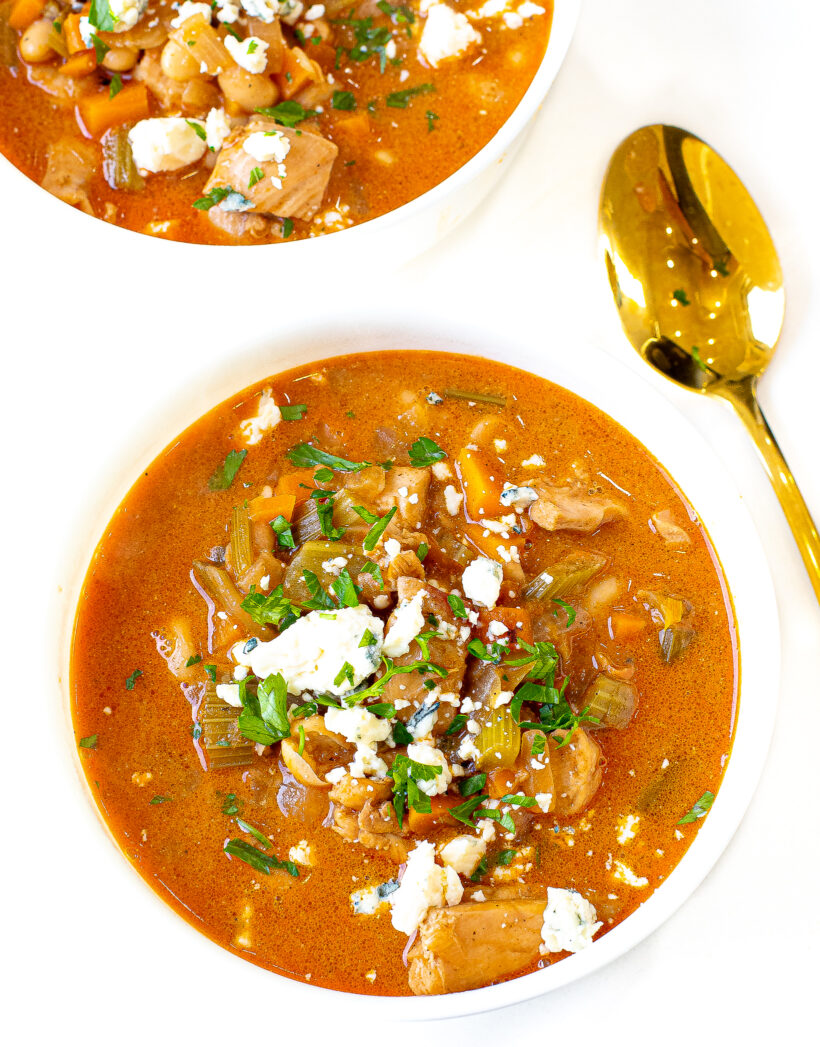 Buffalo Chicken Chili in a white bowl topped with toppings.
