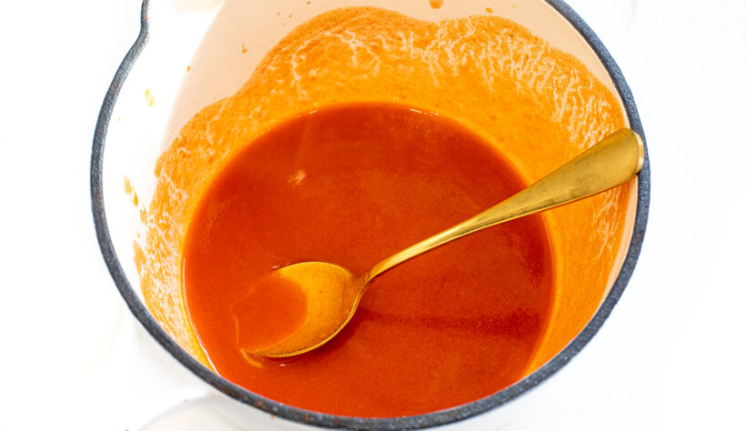Buffalo sauce in a glass mixing bowl.