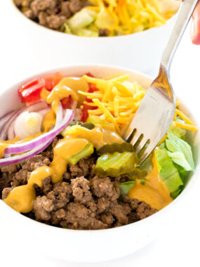 Burger in a Bowl (aka Cheeseburger Salad) in a white bowl with hamburger sauce and cheese | chefsavvy.com