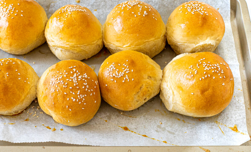 baked homemade burger buns on baking sheet