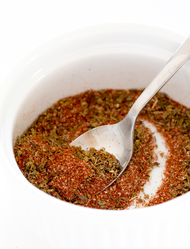 homemade cajun seasoning in white bowl with spoon