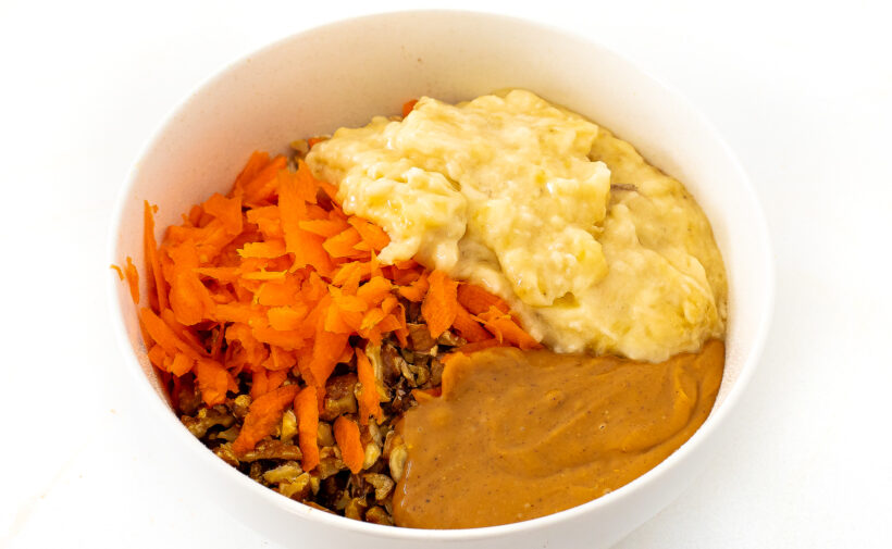 Carrot cake cookie ingredients in a white mixing bowl. 