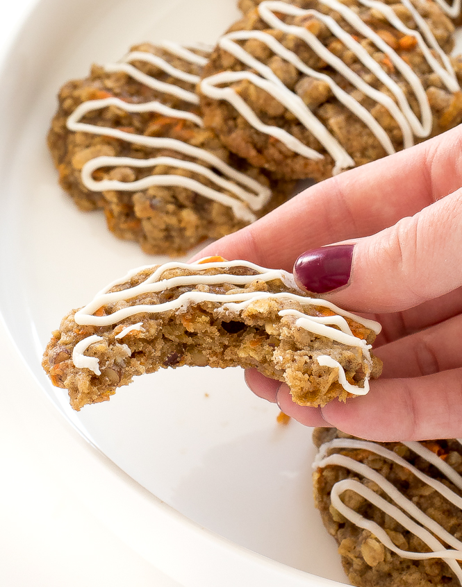 author holding carrot cake cookie with a bite taken out of it