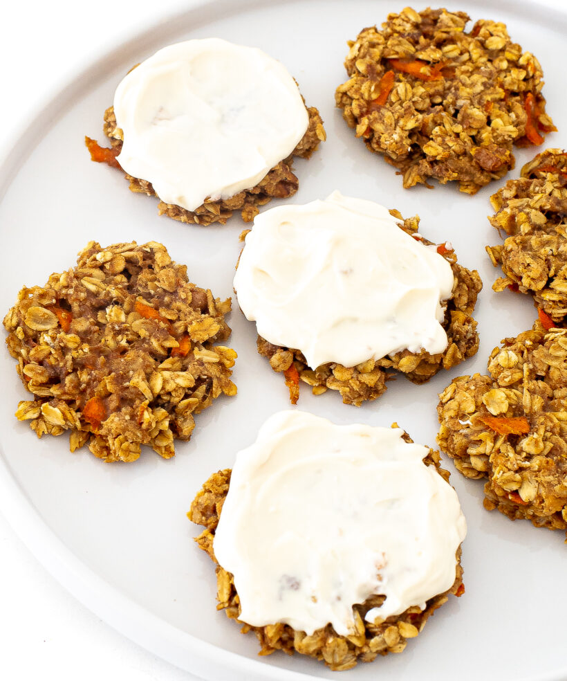 Healthy carrot cake cookies with some of them frosted with cream cheese frosting. 