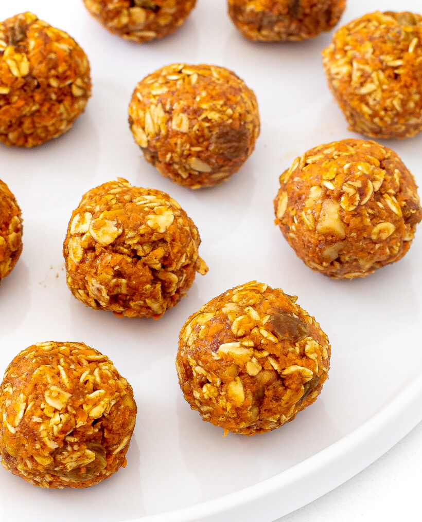 Carrot cake oat energy balls served on a white plate.