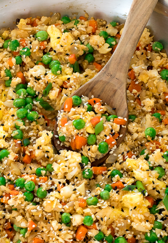 Cauliflower Fried Rice Stir Fry in a pan with a wooden spoon.