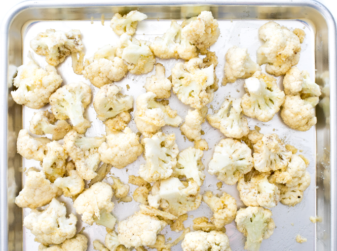 unbaked cauliflower on baking sheet with seasonings