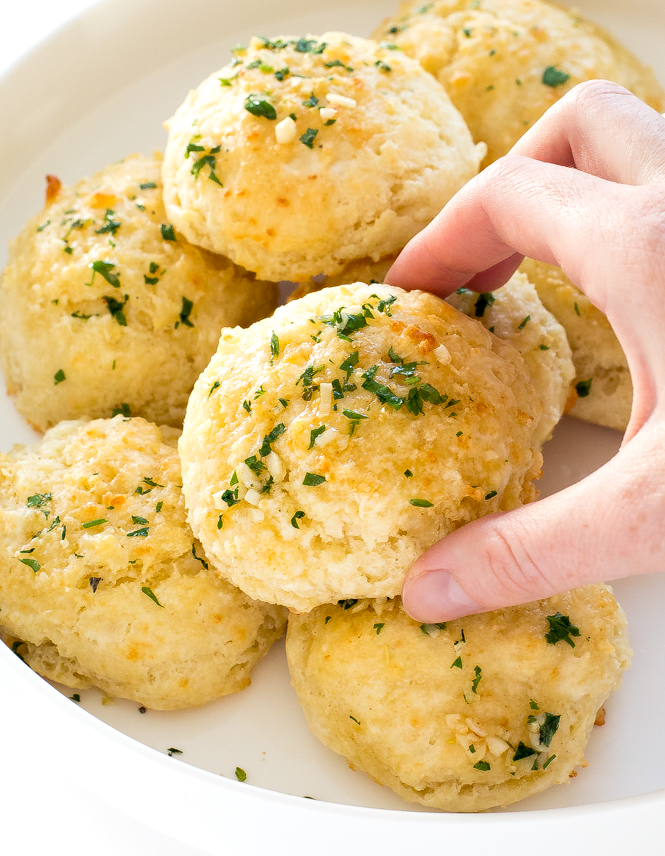 Author grabbing a garlic cheese biscuit off of plate