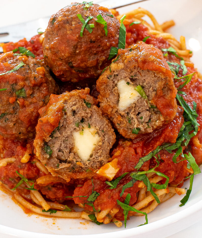 turkey pesto meatballs cut in half to show the cheese stuffed inside the meatballs