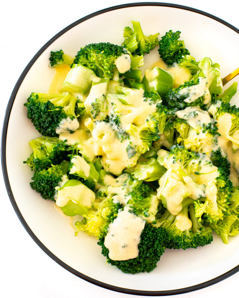 Cheesy Broccoli in a white and black serving bowl.