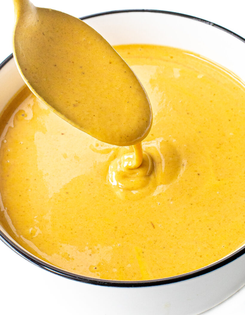 Spoon drizzling chick fil a sauce into bowl.