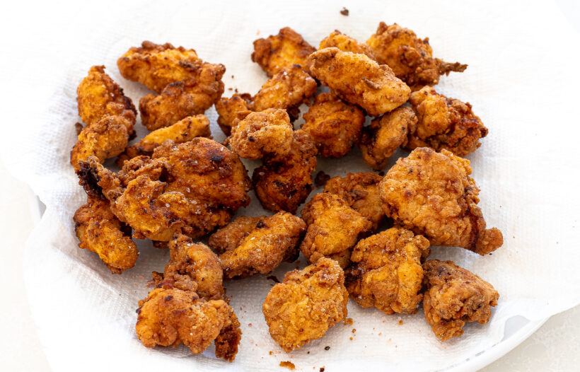 Chicken nuggets after being fried on a paper towel lined plate.