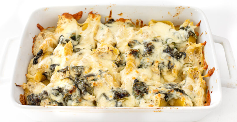 Alfredo stuffed shells in a baking dish after being baked. 